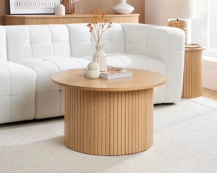 Wooden coffee table in a living room with a white sofa and decorative items.