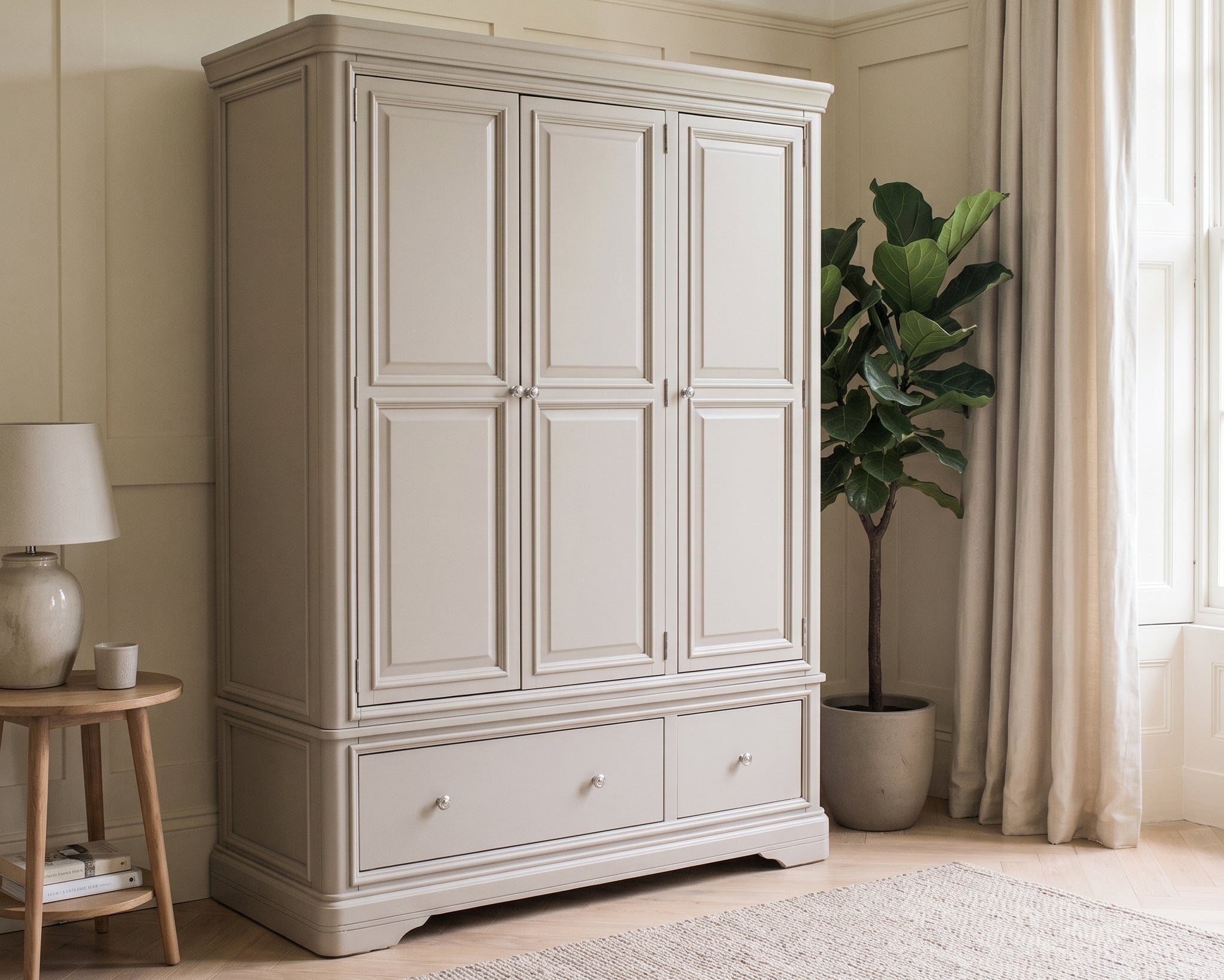 Beige wardrobe in a room with a plant and side table