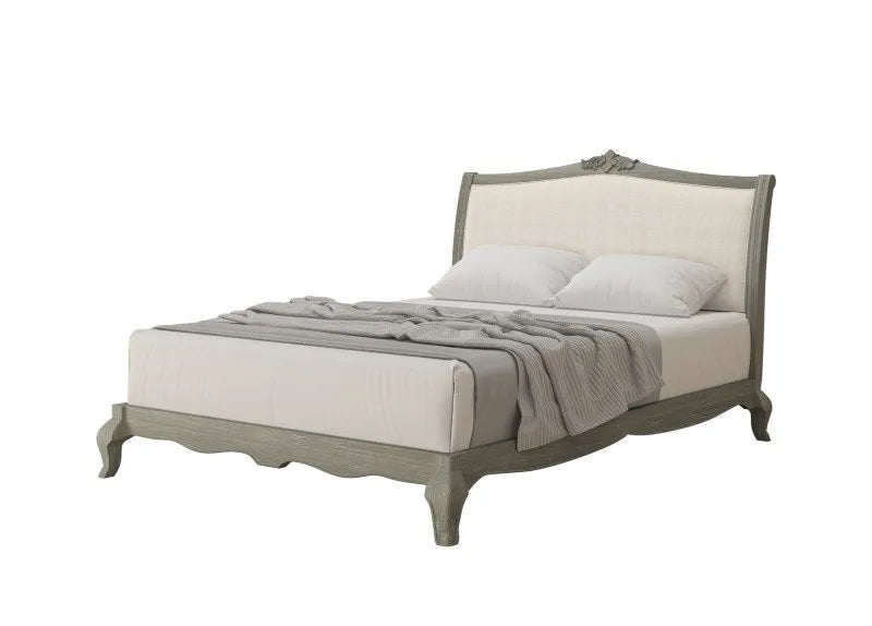 Bed with gray headboard and bedding on a white background