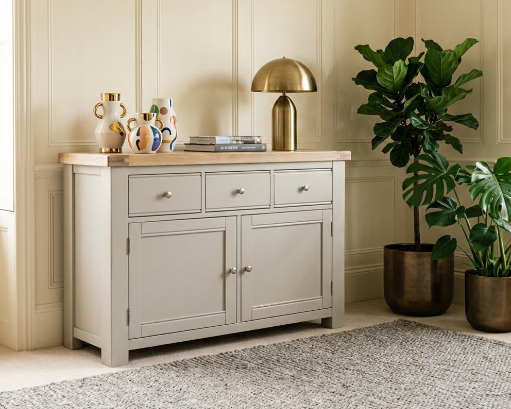 Light gray sideboard with wooden top in a room with plants and decorative items.
