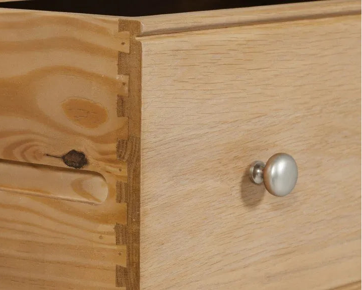 Close-up of a wooden cabinet with a metal knob