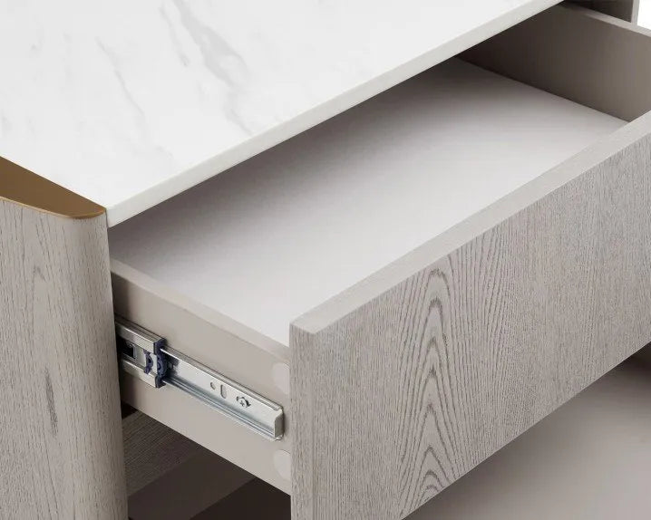Close-up of a light gray wood-grain drawer partially pulled out from a matching cabinet, showing a white marble-look top and metal drawer pull hardware.