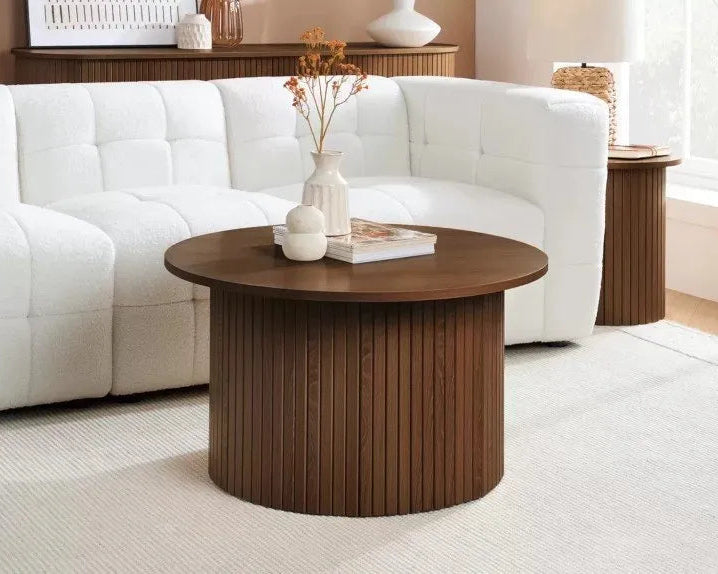 Wooden coffee table in a living room with a white sofa and decorative items.