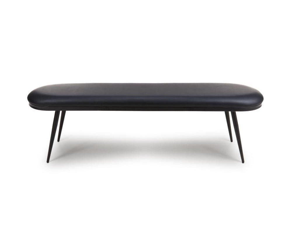 A modern black upholstered bench with a long rounded rectangular seat and four slim angled metal legs, shown against a plain white background.
