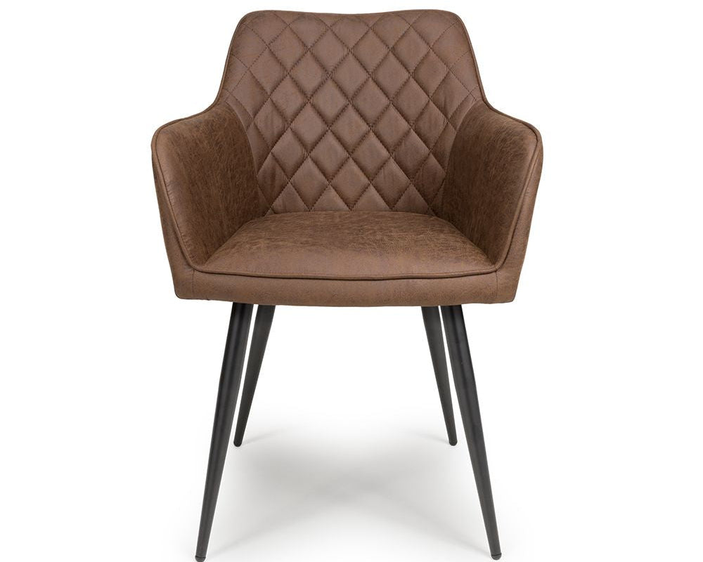 A brown upholstered dining chair with diamond-quilted backrest and seat, curved armrests, and tapered black metal legs, shown on a plain white background.