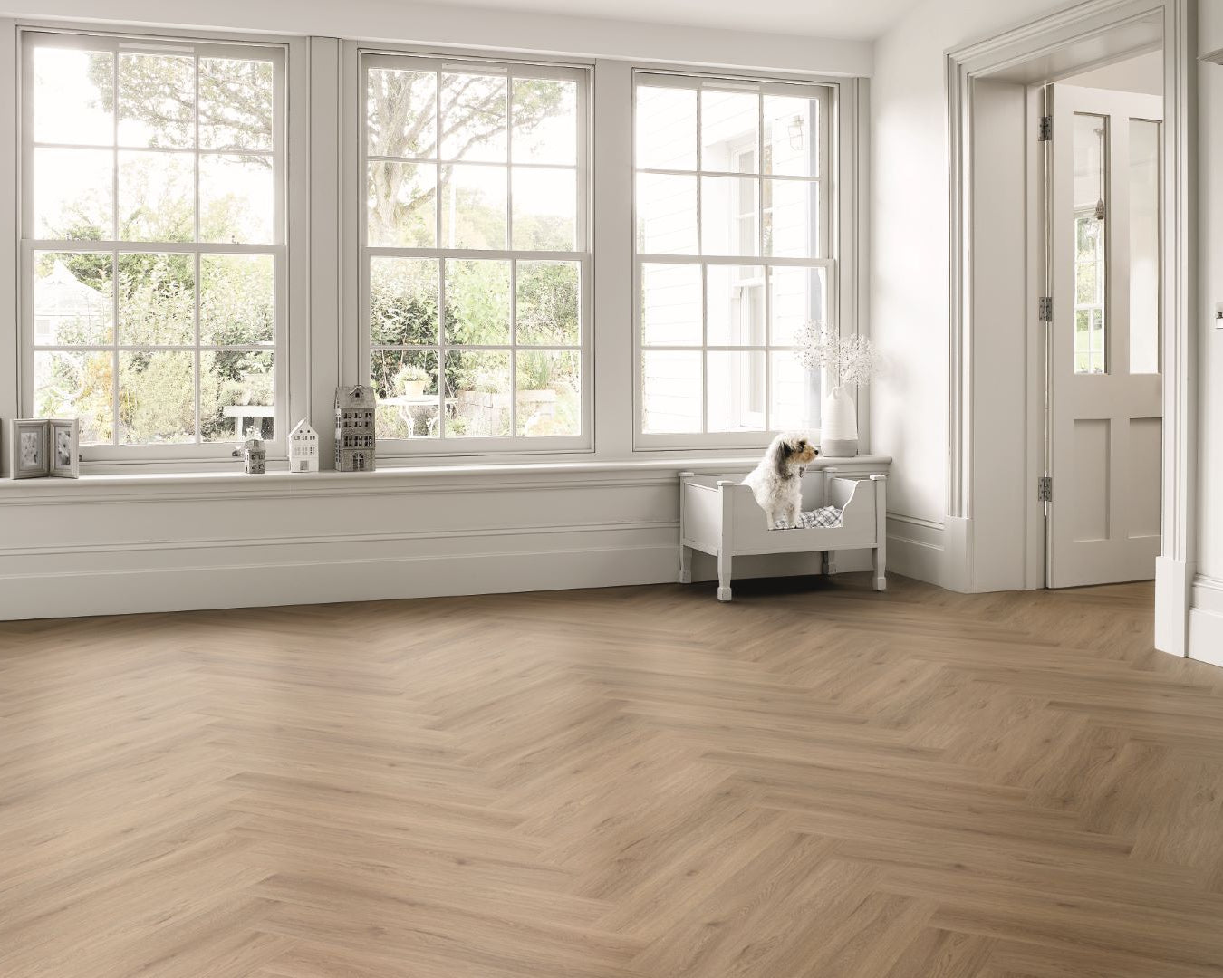 Spacious room with large windows, wooden floor, and white walls.