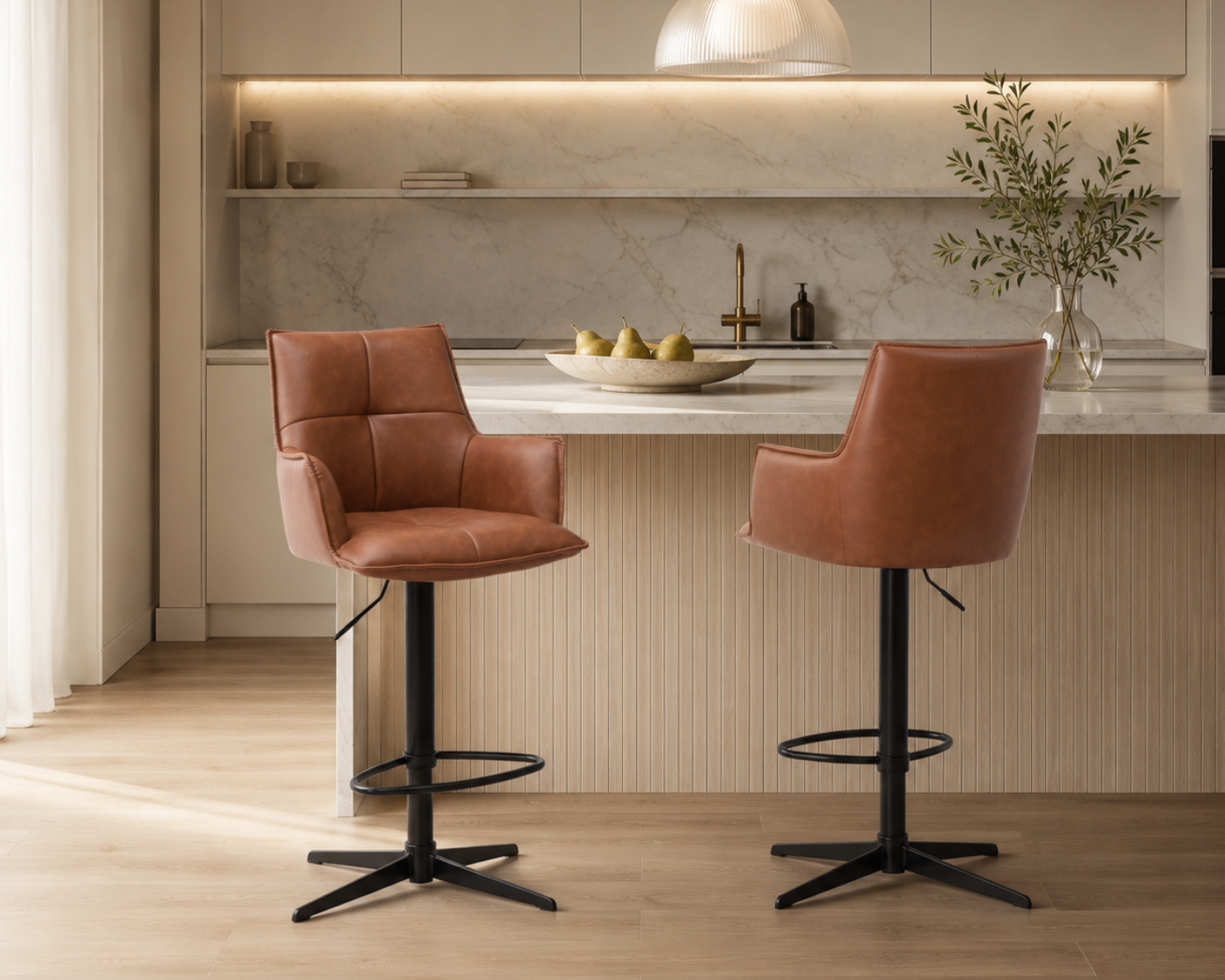 Two brown leather stools with black metal legs in a modern kitchen setting.