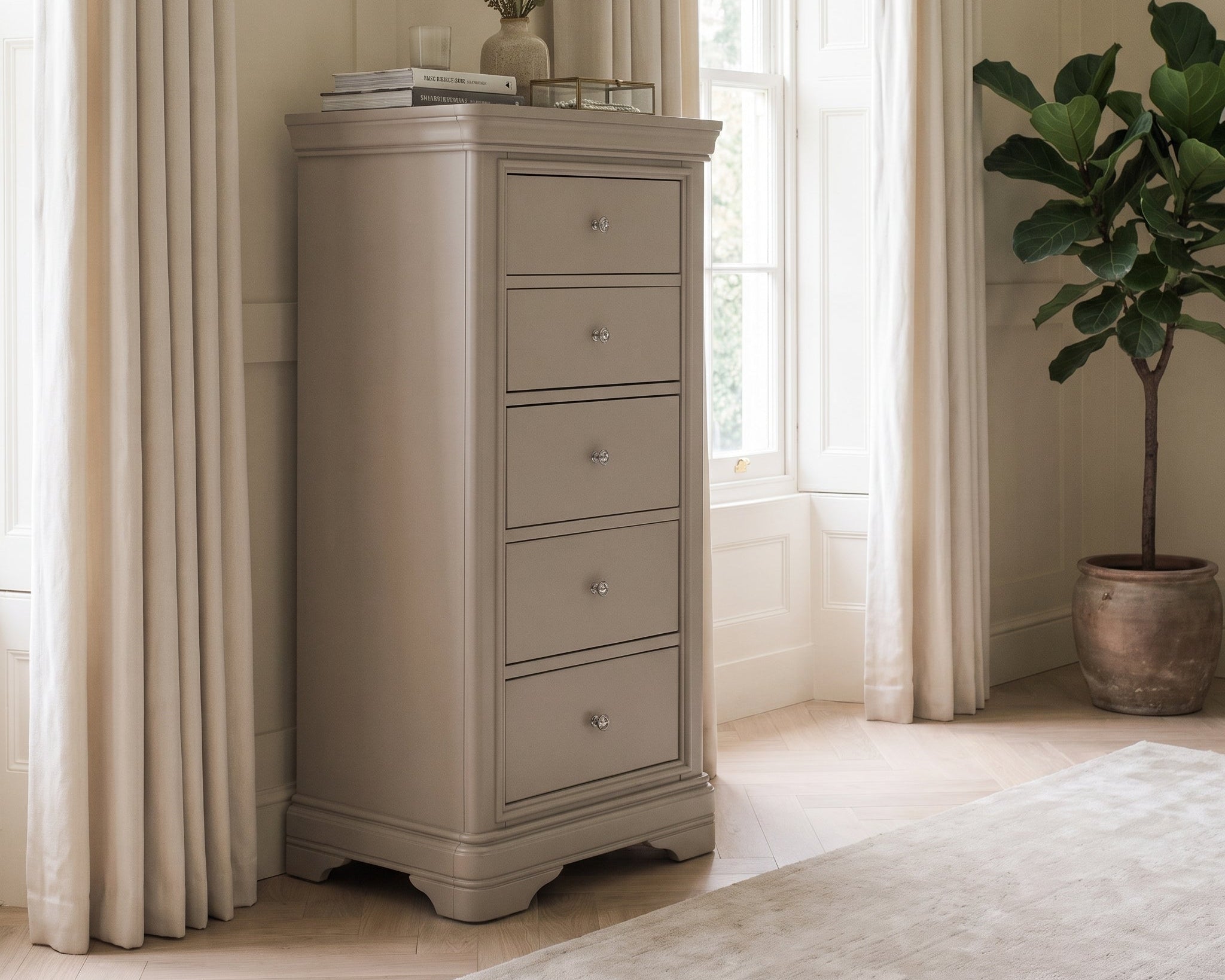 Beige chest of drawers in a room with curtains and a plant