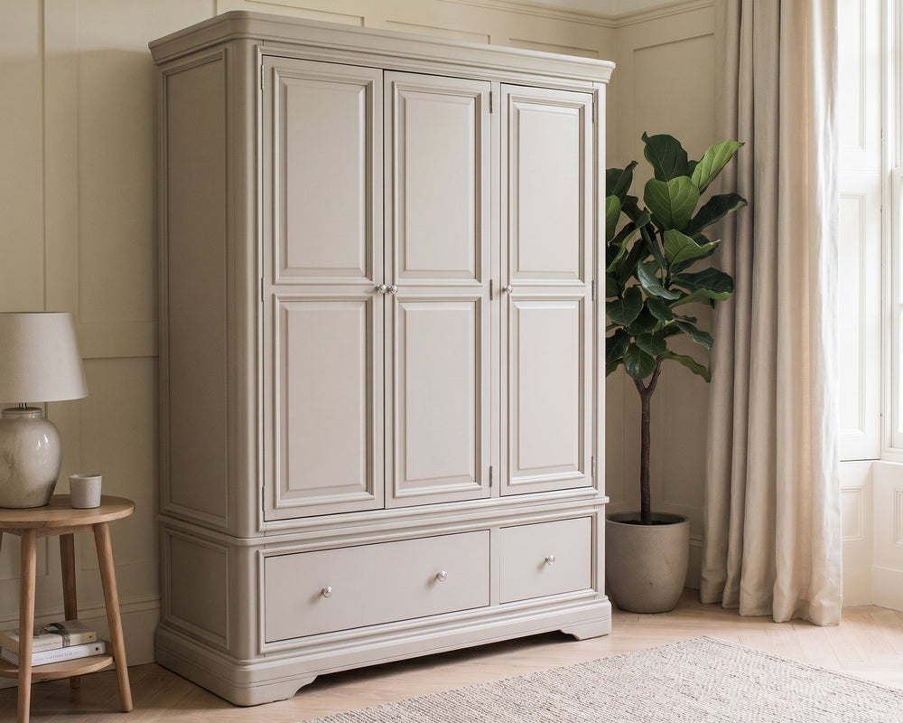 Beige wardrobe in a room with a plant and side table