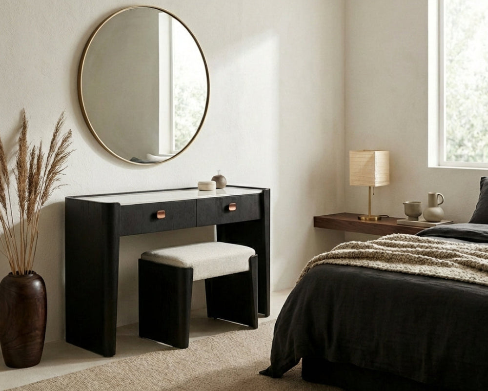 Modern bedroom with black vanity, round mirror, and bed.