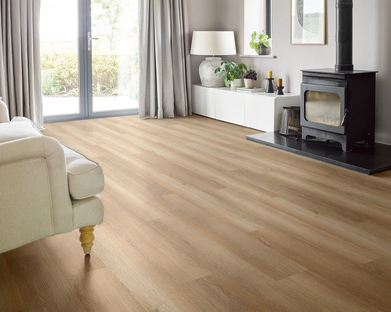 Light oak wood flooring in a modern, bright living room with a black wood-burning stove, white sideboard, and gray curtains.