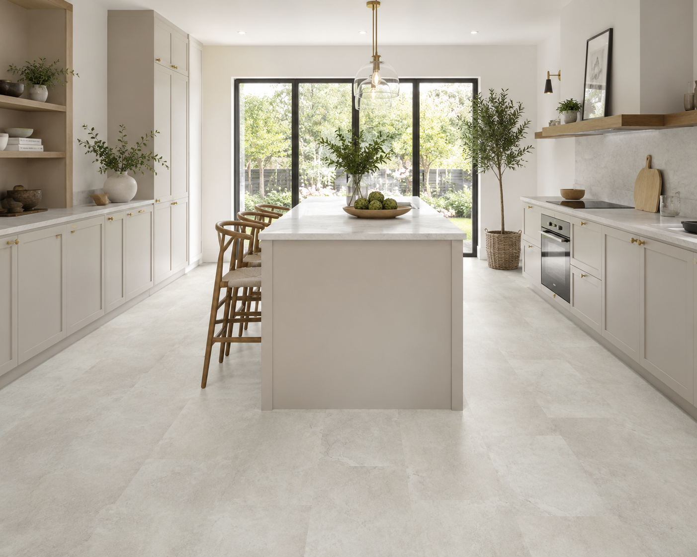 A bright, modern kitchen interior with light beige stone-look floor tiles, white cabinetry, a central island, and large black-framed windows looking out onto greenery.