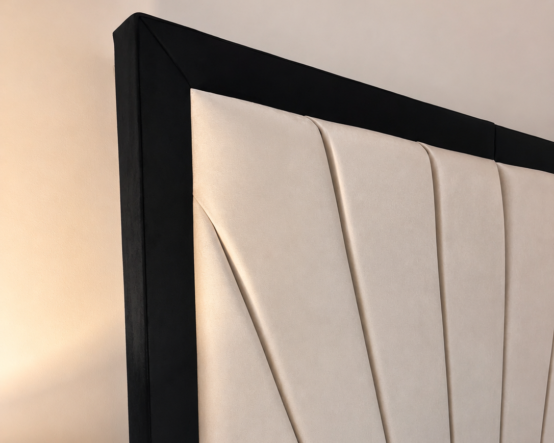Close-up of a beige upholstered headboard with a black frame in a bedroom setting.